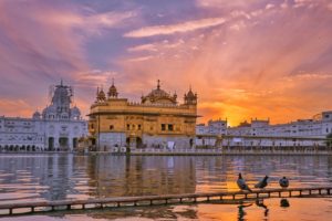 Golden temple near water in evening time